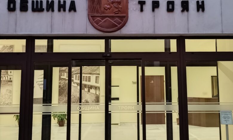   Община Троян е изправена пред сериозен финансов проблем, който застрашава изпълнението на 22 ключови инфраструктурни проекта на обща стойност над 30.4 милиона лева по Инвестиционната програма на МРРБ. Въпреки че строителството по проектите напредва, а три от тях вече са физически завършени, Министерството на регионалното развитие и благоустройството (МРРБ) не превежда своевременно обещаните средства. Създалата се финансова дупка Към момента, изпълнителите са фактурирали извършена работа за 2 532 156,67 лв., но Общината е успяла да плати само 1 822 593,32 лв. Така Община Троян дължи на строителните фирми 709 563,35 лв. за вече завършени дейности. Ситуацията е още по-сложна при авансовите плащания. Въпреки че изпълнителите са предоставили гаранции за 496 885,21 лв., Общината не е могла да преведе тези аванси, тъй като съответните суми все още не са постъпили от МРРБ. От исканите към МРРБ 3 782 180,67 лв., до момента са получени едва 50% или 1 892 220,03 лв. Риск: Спиране на строителството От общинската администрация предупреждават, че това забавяне на плащанията поставя под сериозен риск изпълнението на проектите. Строителите, които не получават средства за извършените дейности, са принудени да спират по-нататъшната работа, което може да доведе до сериозно забавяне на цялата програма. Предложение за спасителен план За да преодолее възникналите затруднения и да запази темпото на работа, Община Троян предлага спешен механизъм за финансиране. Общинският съвет ще бъде призован да даде съгласие временно свободните общински средства да бъдат използвани като оборотни. Според проекта за решение, Общинският съвет Троян трябва да даде съгласие за извършване на разплащания с бюджетни средства в размер до 2 000 000 лева към изпълнителите на проектите. Тези средства ще бъдат използвани като мост, докато бъдат възстановени и верифицирани от МРРБ. С това решение Община Троян се надява да гарантира непрекъснатата работа по важните инфраструктурни обекти и да избегне провала на инвестиционната програма.